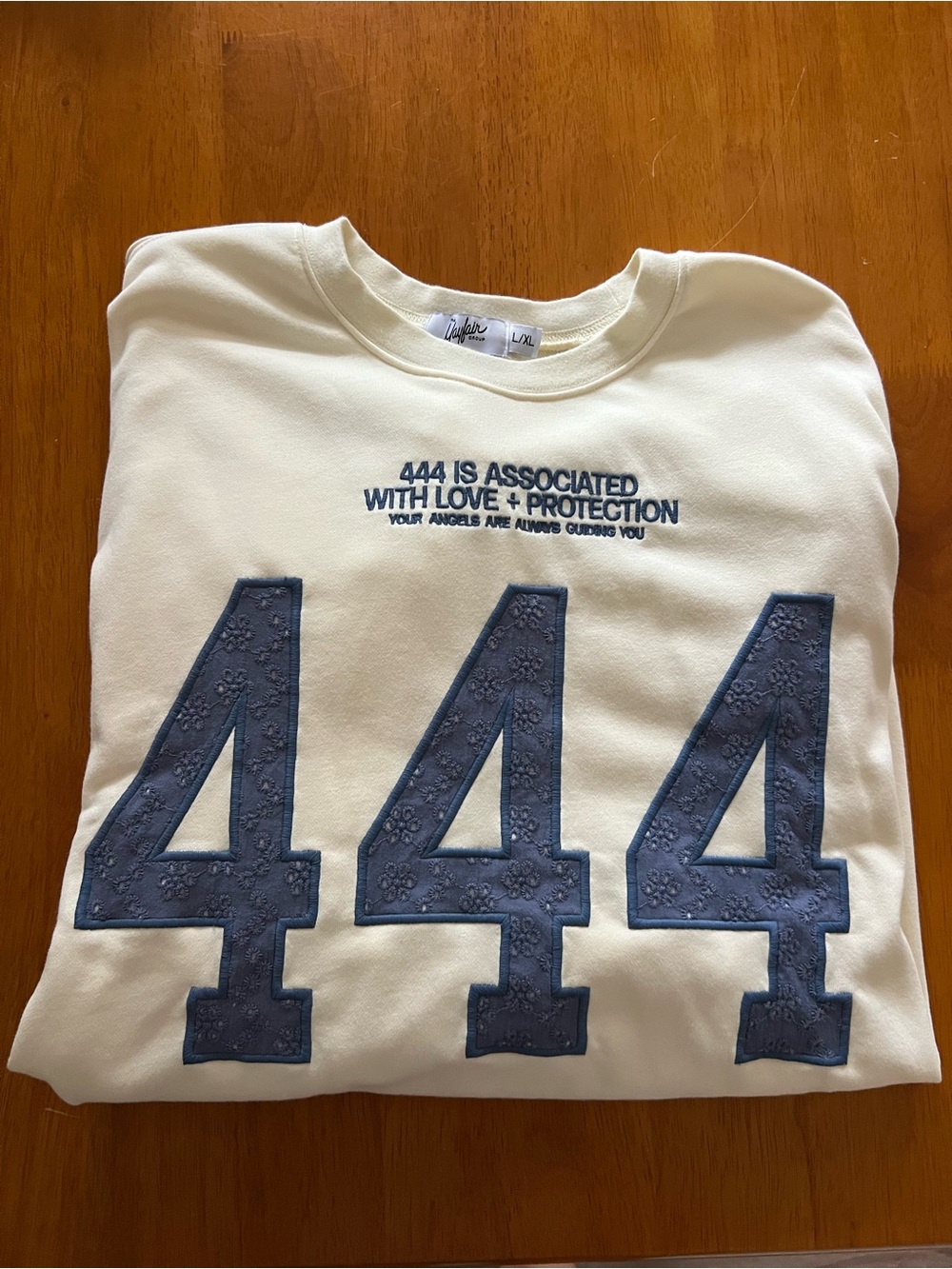 The Mayfair Group 444 Graphic Crewneck Sweatshirt - Cream with Blue Applique